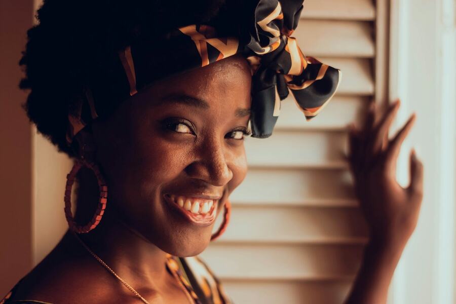 Smiling host standing by a window at home